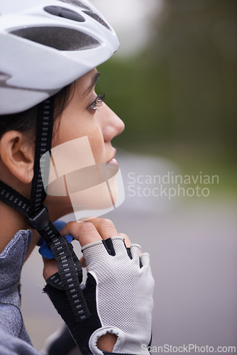 Image of Cycling, woman and adjust helmet for safety, protection and exercise gear to travel outdoor. Bicyclist, person and putting on hat in preparation for training, sports or closeup for fitness in profile