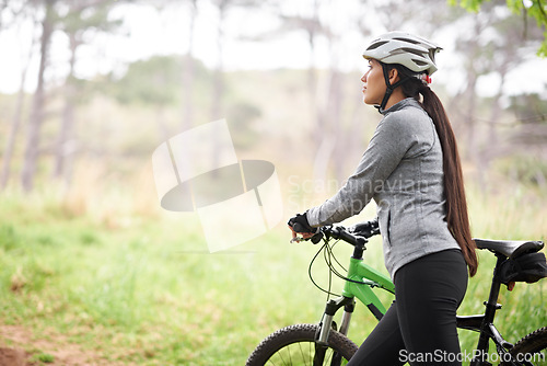 Image of Nature, cycling and woman with bicycle for fitness in an outdoor park training for race or marathon. Sport, exercise and female athlete cyclist walking with bike for workout in field, woods or forest