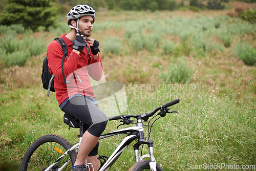 Image of Fitness, bike and man cycling with helmet for adventure, discovery or off road sports hobby. Exercise, health and safety with young cyclist on bicycle in countryside for cardio training or workout