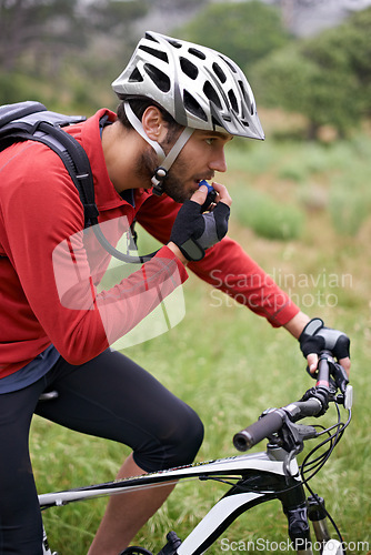Image of Fitness, cycling and drinking water with man in countryside for adventure, discovery or off road sports hobby. Exercise, health and hydration with young athlete on bike for cardio training or workout