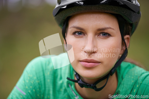 Image of Portrait, cycling and helmet with woman closeup in nature for fitness, training or off road hobby. Face, exercise and health with confident young athlete or cyclist outdoor in countryside for cardio