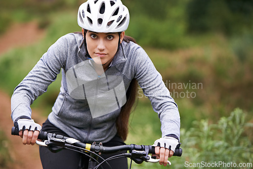Image of Nature, cycling and woman cyclist with bicycle for fitness in an outdoor park training for race or marathon. Sport, exercise and female athlete riding bike for cardio workout in field or forest.