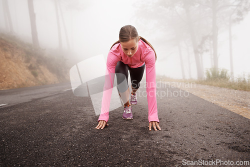 Image of Runner, start and woman on path outdoor in forest, park or woods for exercise in winter. Morning, fog and person with fitness challenge or prepare for workout on road in countryside with nature