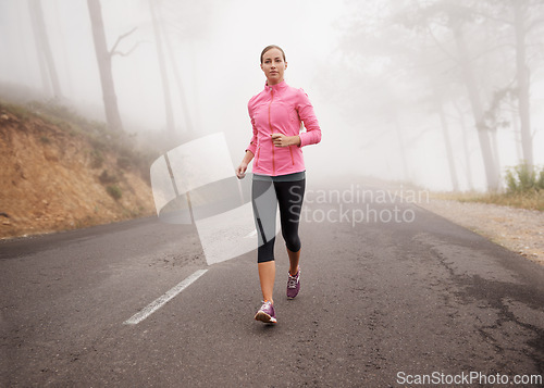 Image of Nature, sports and woman running in fog on mountain road for race, marathon or competition training. Fitness, exercise and female athlete with cardio workout in misty outdoor woods or forest.