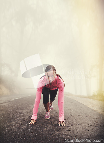 Image of Runner, start and woman ready outdoor in forest, park or woods for exercise in winter. Morning, fog and person with fitness challenge or training in workout on road in countryside with nature