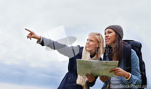 Image of Woman, friends and pointing with map for direction or location on hiking adventure together in nature. Young female person, hiker or team with travel guide for destination, route or outdoor path