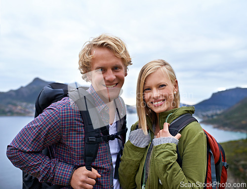 Image of Happy couple, portrait and hiking with backpack on mountain for sightseeing, travel or outdoor journey in nature. Face of young man, woman or hikers carrying bag for trekking, fitness or adventure