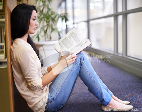 Image of Student, reading and knowledge from education in library, calm and research for assignment or homework. Girl, learning and study with book in school, information and proud for literature in college