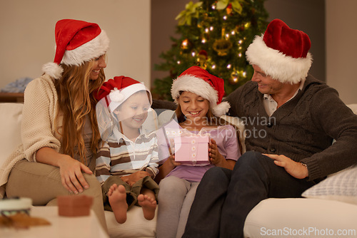 Image of Family, living room and christmas with gift, excitement and joy with home on sofa. Parents, children and celebration with present, gratitude and thank you with happiness or appreciation for holiday