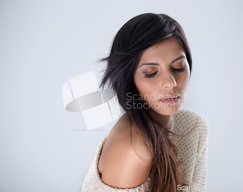 Image of Woman, fashion and hair, makeup in studio for winter style and eyes closed, salon treatment and wellness on white background. Cosmetics, trendy jersey or sweater with haircare, volume and growth