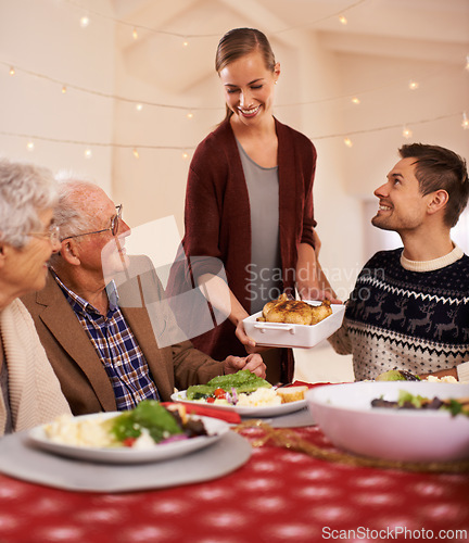 Image of Christmas, dinner and family smile at table together with food and celebration in home. Senior, mother and father with happiness at lunch with woman hosting holiday with dish of chicken on plate