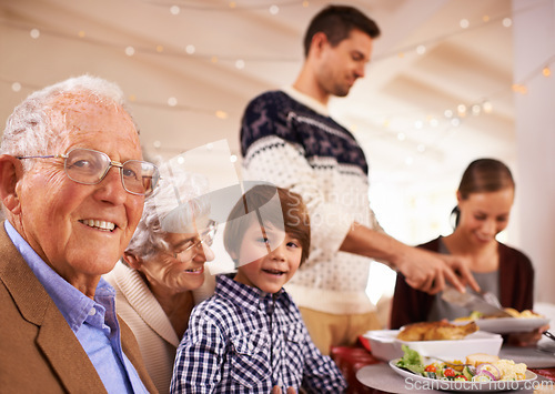 Image of Grandparents, portrait and family at dinner on Christmas, together with food and celebration in home. Happy, event and kid smile with old man at lunch and relax on holiday at table with grandmother