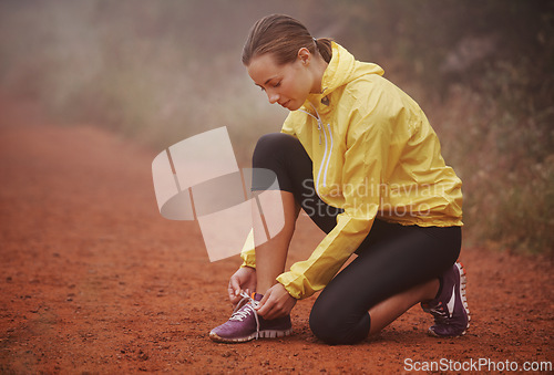 Image of Running, shoelace and fitness woman in park for training, exercise or wellness in winter. Workout, sneakers or runner in nature for morning cardio preparation, sports or shoes check for marathon run