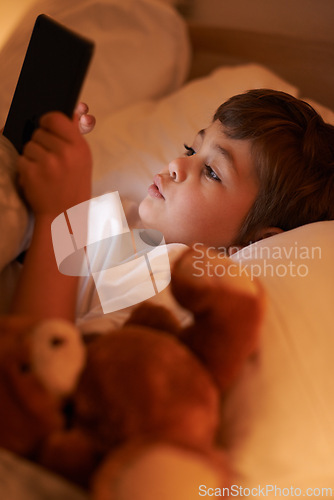 Image of Boy, tablet and bedroom with night, connection and technology for social media or learning. Child, bed and connectivity for knowledge, elearning and internet surfing at home or house with touchscreen