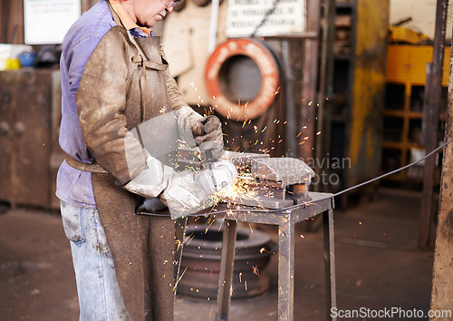 Image of Blacksmith, man and grinder for metal with sparks, design or industry for metallurgy in factory. Person, worker or small business owner with power tools, steel or iron with manufacturing in warehouse