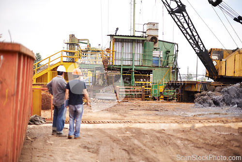 Image of Crane, machine and engineer men in scrapyard to recycle metal for sustainability, manufacturing or pollution. Vehicle, people and outdoor in junkyard for ecology with back, industry and environment