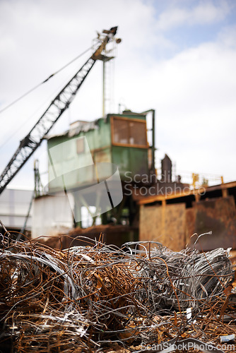 Image of Crane, machine and junkyard for moving metal with sustainability, manufacturing or stop pollution. Vehicle, tractor and outdoor in scrapyard, plant or ecology for iron, steel industry and environment