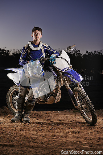 Image of Extreme sport, portrait and man with off road motorcycle, confidence and gear for competition, race or challenge. Adventure, adrenaline and serious face of athlete on course with dirt bike in evening