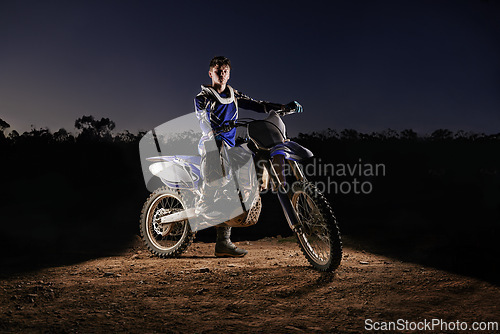 Image of Extreme sport, portrait and man with dirt bike, confidence and gear for competition, race or challenge. Adventure, adrenaline and serious face of athlete on course with off road motorbike at night