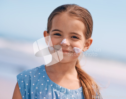 Image of Child, portrait and smile with sunscreen on beach or summer protection or travel adventure, safety or holiday. Female person, girl and face or skincare lotion in Australia for vacation, break or trip