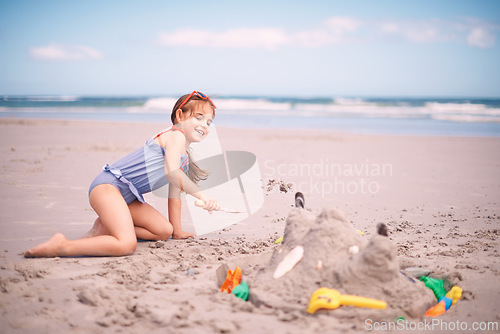 Image of Happy girl, toys and playing with beach sand, castle or summer fun on outdoor holiday or weekend in nature. Female person, child or kid with smile for water or building sandcastle by ocean coast