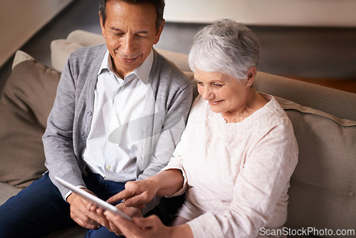 Image of Senior, couple and happiness with tablet on sofa for online bingo, crossword puzzle or internet games in living room. Elderly, man and woman with face or top view with technology for web news in home