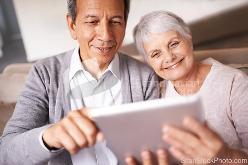 Image of Senior, couple and smile with tablet on sofa for online bingo, crossword puzzle and internet games in living room. Elderly, man and woman with face and happiness with technology for web news in home