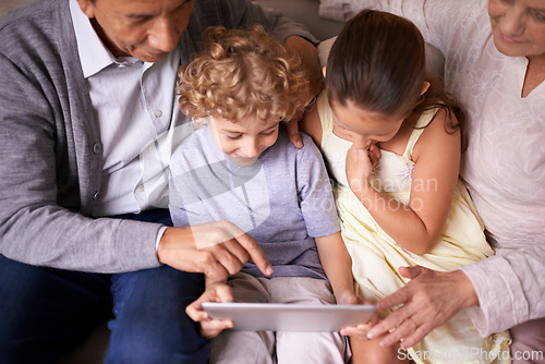 Image of Family, children and grandparents pointing with tablet for entertainment or social media on sofa at home. Grandma, grandpa and showing kids interaction with technology for bonding or game at house