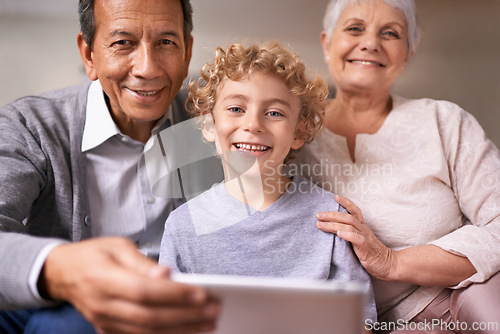 Image of Happy family, portrait and grandparents with child on tablet for entertainment, social media or research on sofa at home. Grandma, grandpa and kid smile with technology for online connection at house