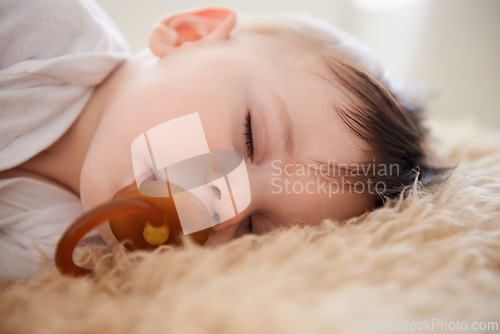 Image of Baby, sleeping and pacifier with relax in home for healthy development, growth and tired in bedroom. Child, rest and dummy in mouth with nap, dreaming and wellness in nursery of house or apartment