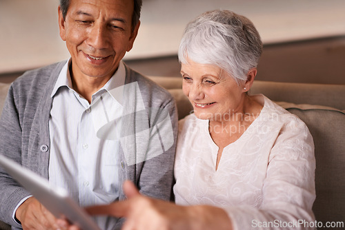 Image of Senior, couple and happiness with tablet on couch for online bingo, crossword puzzle and internet games in living room. Elderly, man and woman with face or smile with technology for web news in home