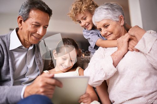 Image of Happy family, grandparents and children with tablet on sofa for entertainment or social media at home. Grandma, grandpa and kids with smile, hug and love on technology for bonding or game at house