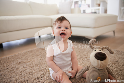 Image of Baby, teddy bear and toy on living room floor or morning playing in home for resting development, childhood or happiness. Kid, boy and lounge in apartment by couch for weekend joy, fun or relaxing