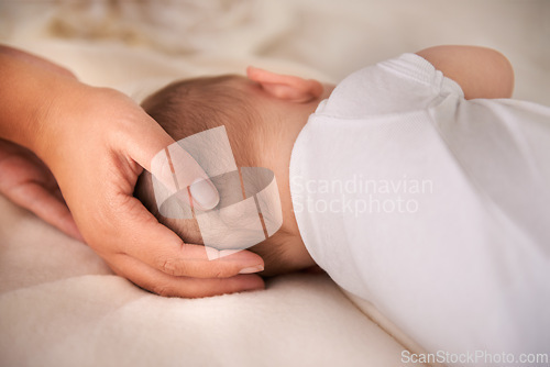 Image of Baby, sleeping and hands of parent on bed for care, love or support for protection in home. Kid, closeup or infant resting with family in bedroom for peace, calm or comfort of innocent child in house