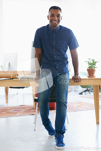 Image of Black man, intern and portrait in office for creative career, working or excited for new job. South African male, copywriter or documents on desk at workplace for development, growth or opportunity