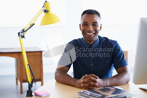 Image of Young businessman, portrait and happy in office by desk, consultant and creative in career. Smile, black man or positive face of journalist in co working space or professional for ambition in company