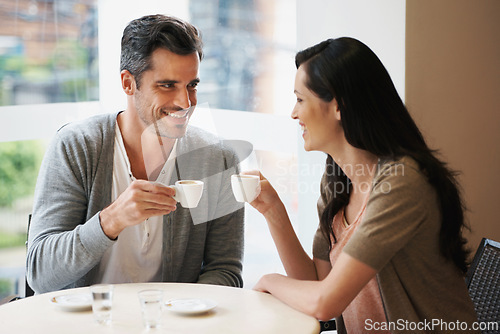 Image of Love, conversation and couple with coffee on date for romance or anniversary in cafeteria. Happy, bonding and young man and woman talking and drinking latte, espresso or cappuccino at restaurant.