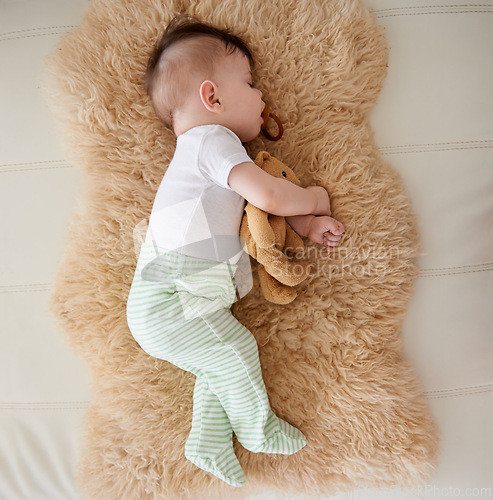 Image of Baby, sleeping and dummy with relax in home for healthy development, growth and tired with top view. Child, rest and pacifier in mouth with nap, dreaming and wellness in nursery of house or apartment