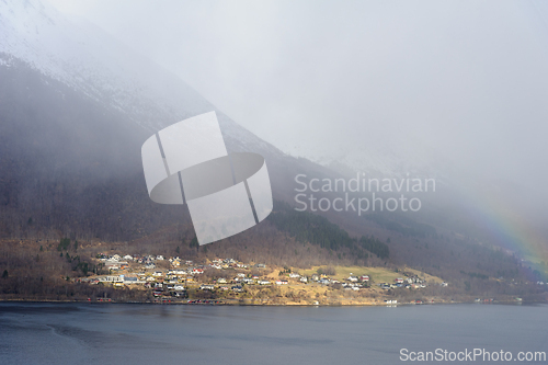 Image of Misty seaside village at the foot of a mountain on a cloudy day