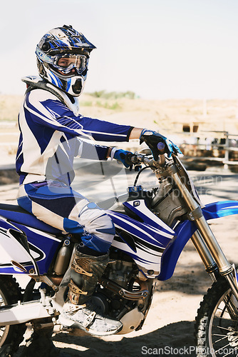 Image of Motorcycle, extreme sport and portrait for person on trail for competition, race or games with speed. Racer, motorbike and helmet for contest, motor cross and fast transport with sunshine in desert