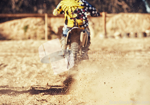 Image of Person, motorcyclist and dust with dirt bike on track for race, extreme sports or outdoor competition. Rear view of expert rider on motorbike, scrambler or sand course for off road rally challenge