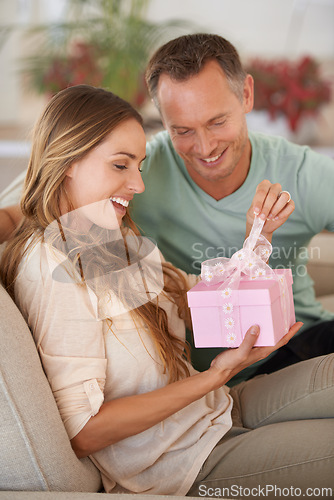 Image of Woman opening gift, man and happiness with surprise for birthday or anniversary, love and support with romance. Couple in marriage, unboxing package with ribbon and present for token of appreciation