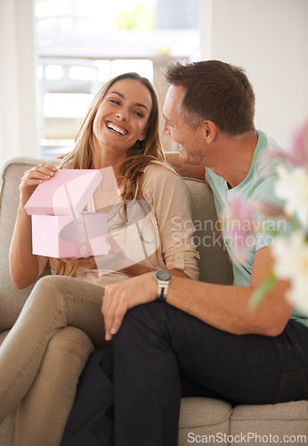 Image of Happy woman opening present, man and smile with surprise for birthday or anniversary, love and support with romance. Couple in marriage, unboxing package and gift giving for token of appreciation