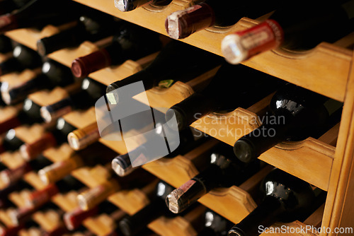 Image of Wine cellar, bottle and storage on rack in basement for restaurant stock, winery and shelf with alcohol display. Warehouse, drinks collection and beverage stack in vineyard with arrangement and row