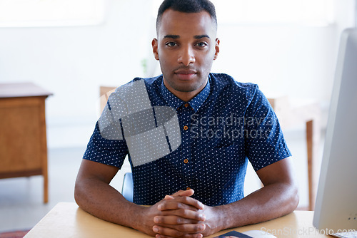 Image of Business, portrait and confident black man at desk in workplace, office or startup company for job of employee. Face, table and serious entrepreneur, creative and designer working in South Africa