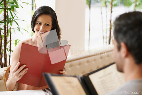 Image of Couple, restaurant and menu for meal selection, conversation and bonding on valentines day. People, love and romance at cafe or lunch choice for anniversary celebration, cuisine and happy at bistro