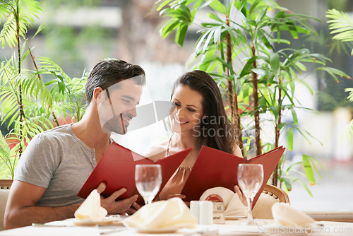 Image of Couple, restaurant and reading a menu on date, fine dining and bonding on valentines day. People, love and romance at cafe or lunch choice for anniversary celebration, cuisine and happy at bistro