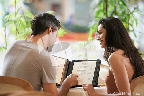 Image of Couple, restaurant and reading a menu for selection, decision and bonding on valentines day. People, back and romance at cafe or lunch choice for anniversary celebration, cuisine and happy at bistro