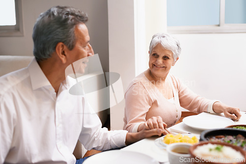 Image of Senior couple, dinner and holding hands in home dinning room, praying and gratitude for meal. Grace, smile and love at thanksgiving lunch, retired and elderly people enjoying family time in America