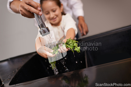 Image of Child, washing and kitchen sink with salad, food and cleaning for cooking in a home. Water, health and happy girl with herb and helping for lunch and meal together with youth and learning hygiene